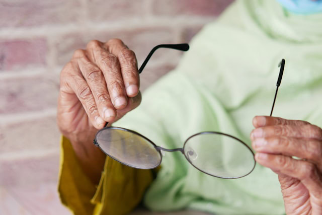 Someone holding up a pair of glasses